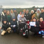 Connor Head picks up his new electric wheelchair from volunteers at the Barton Hill RFC Charity Cafe